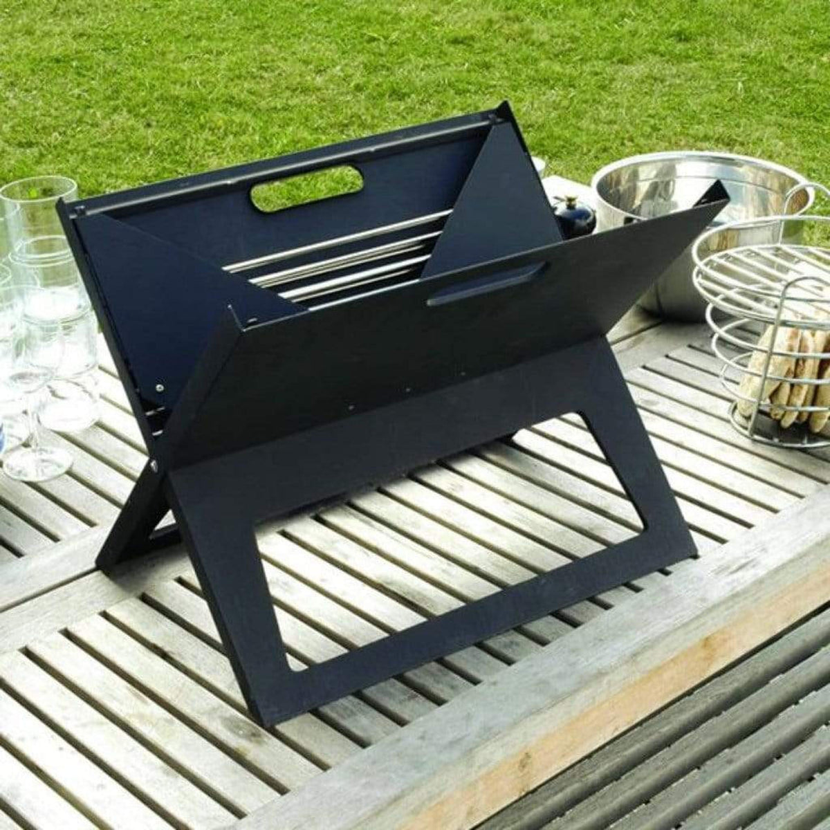 Fire Sense Notebook portable charcoal grill folded open on a table – view 3