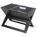 Fire Sense Notebook portable charcoal grill folded open on a table